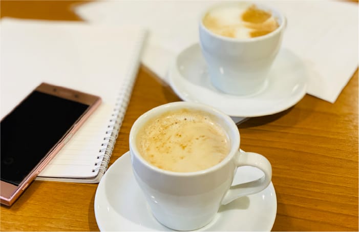 コーヒーとノート・スマートフォンの写真